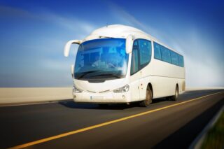 white touristic bus in motion on the highway and blurred background